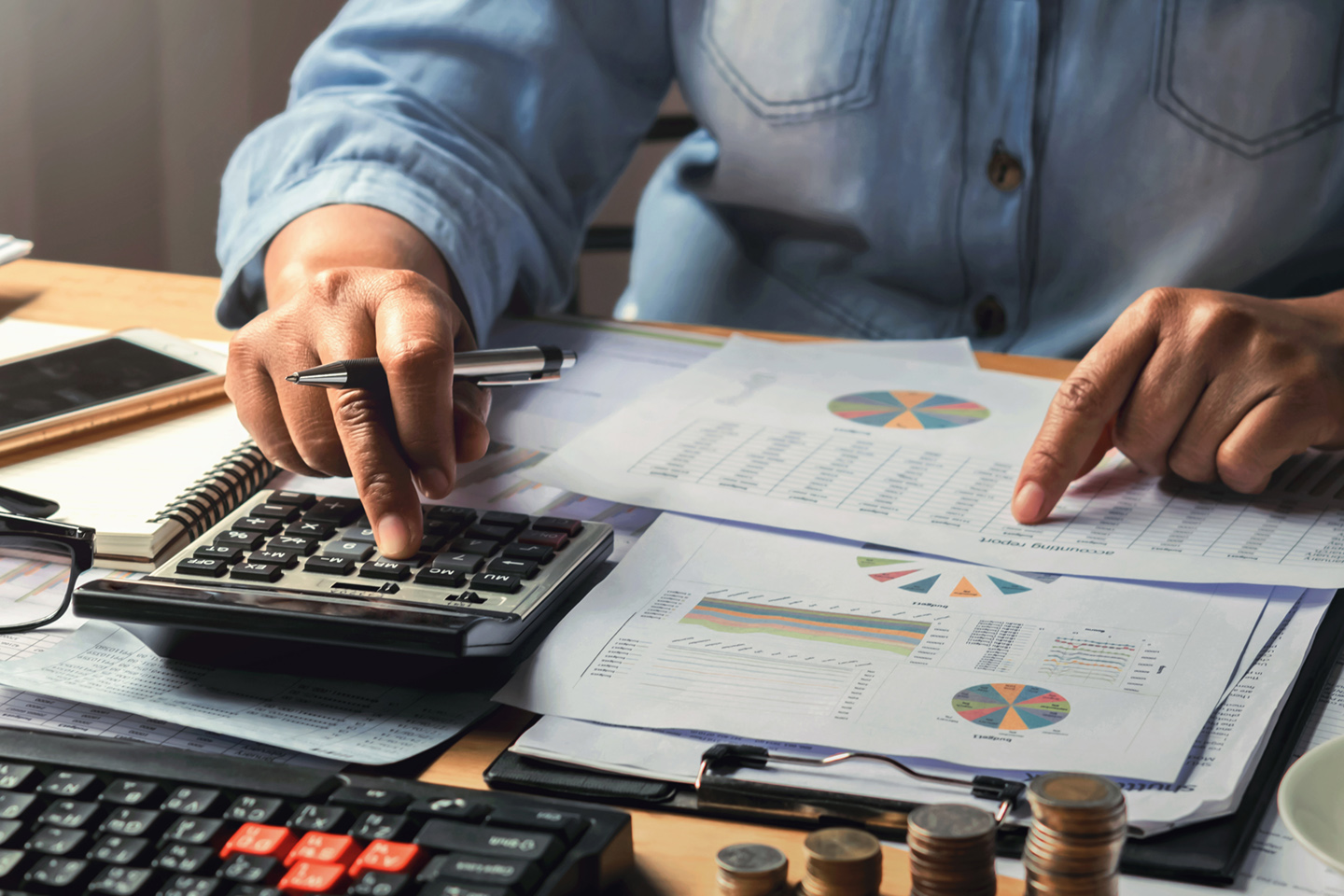 accounting concept. businesswoman working using calculator with money stack in office